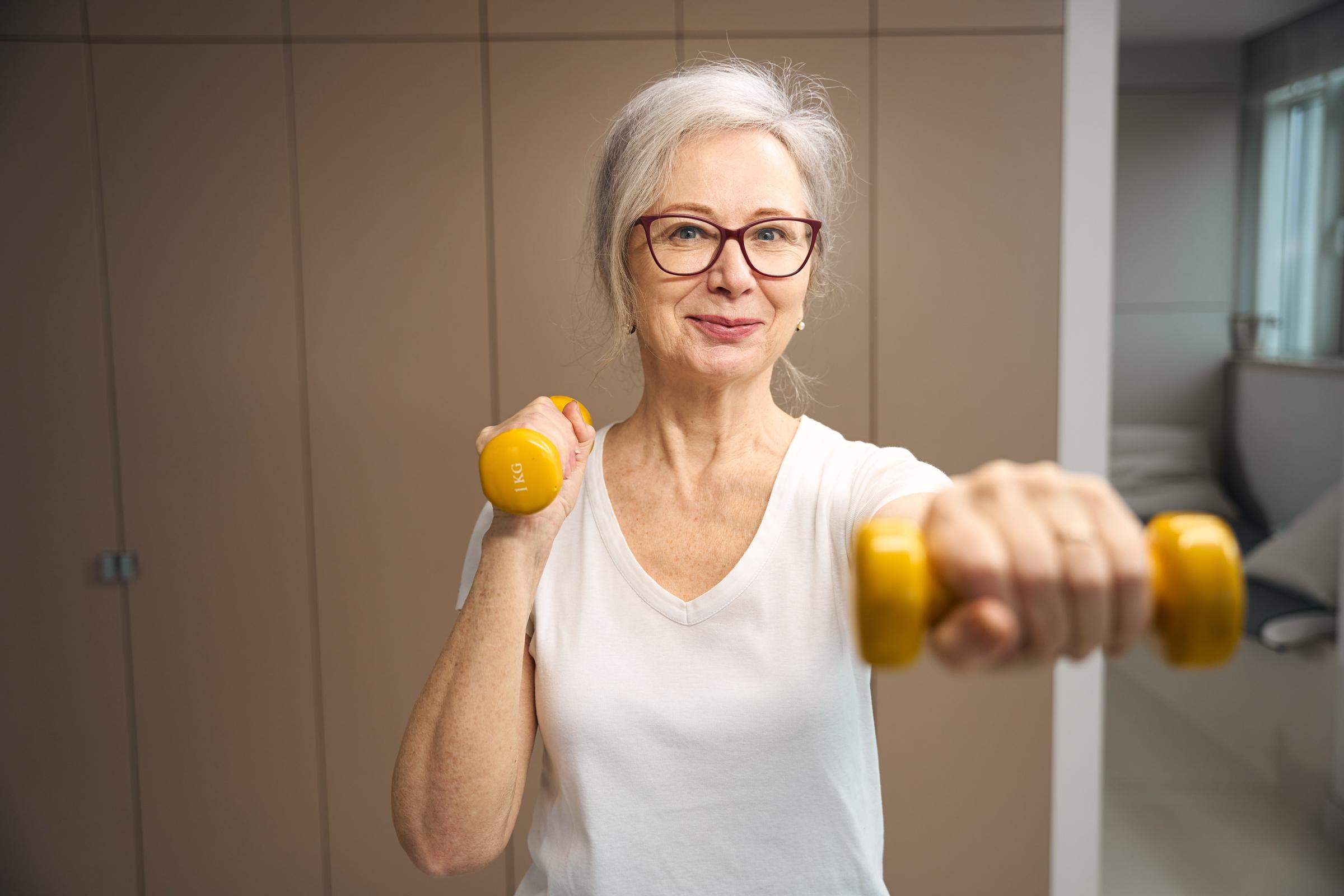 Kobieta ćwicząca z hantlami | Źródło: Shutterstock