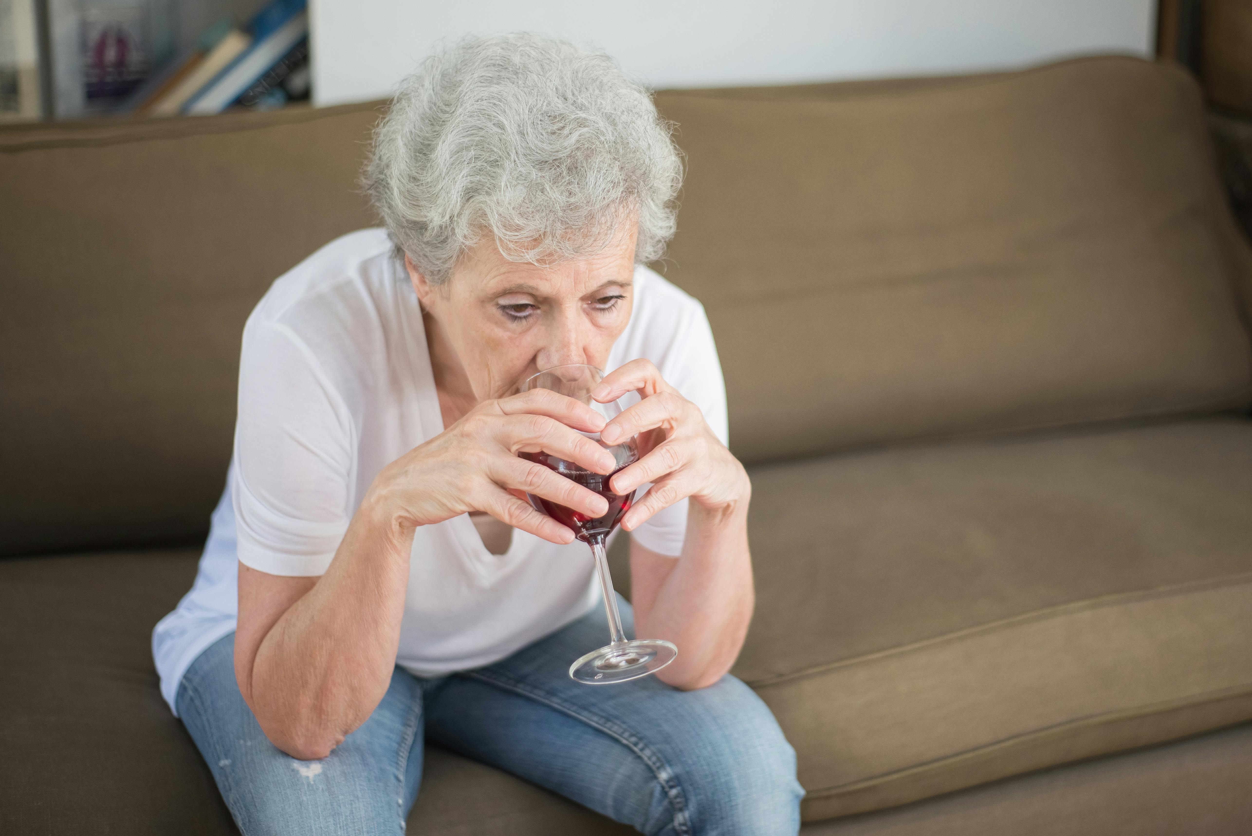 Smutna kobieta pijąca wino w samotności | Źródło: Pexels