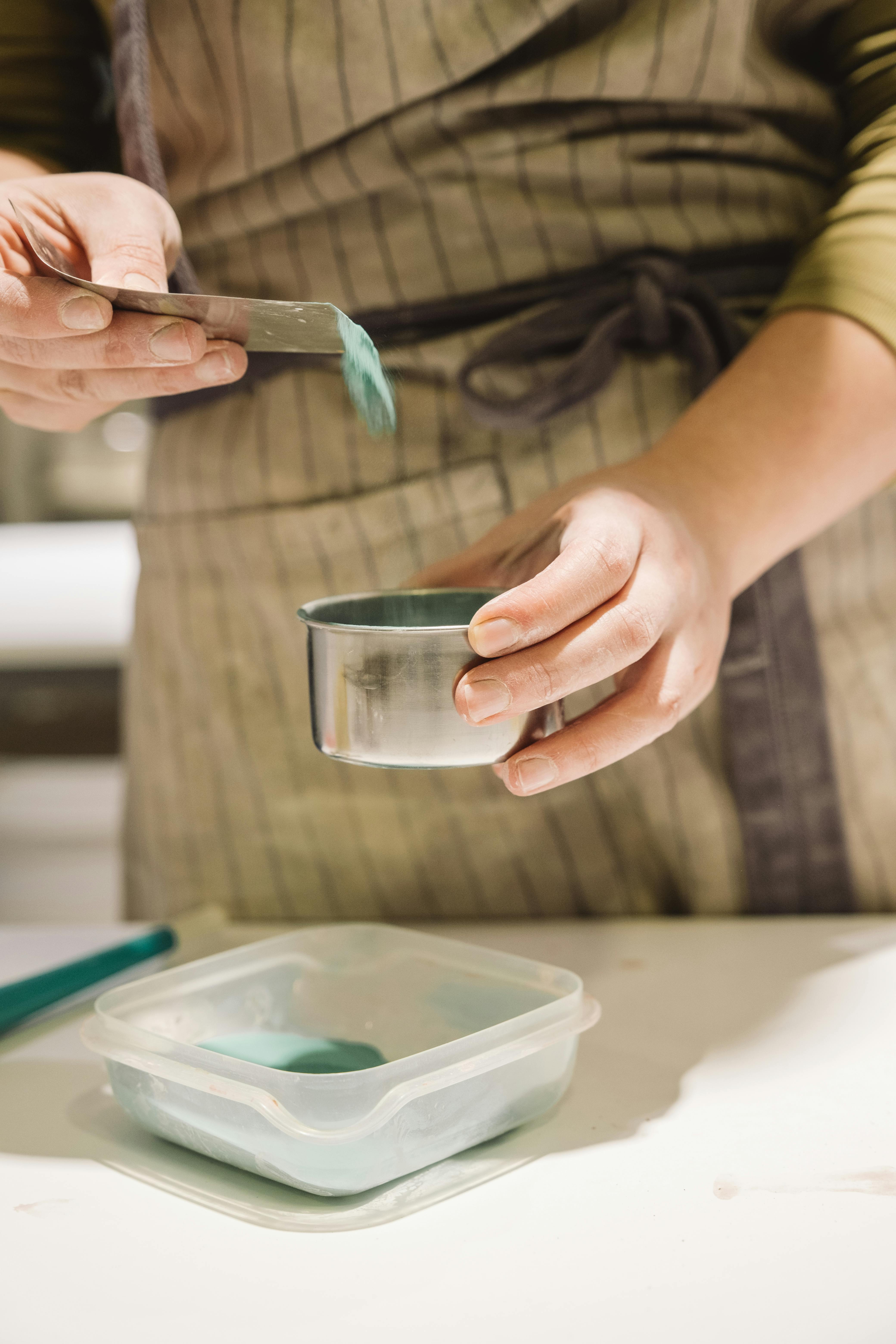 Ktoś wlewa zielony barwnik do miski | Źródło: Pexels