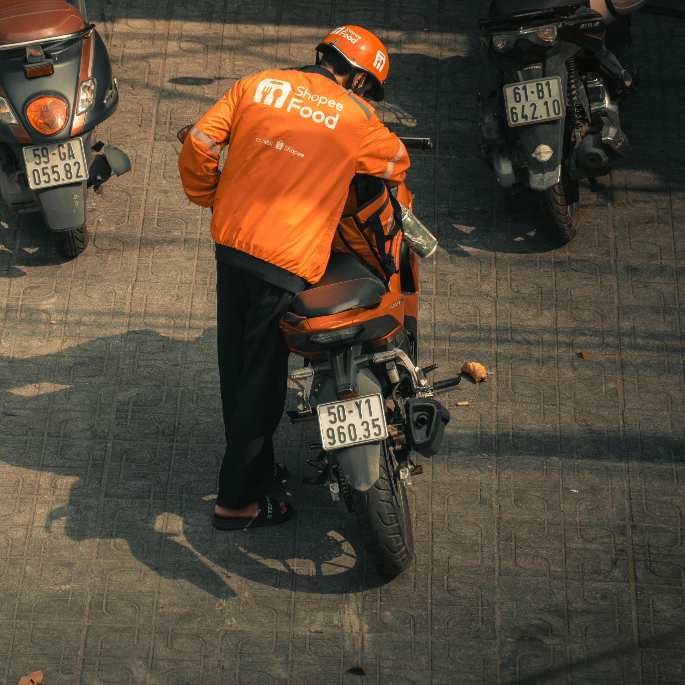 Dostawca jedzenia wsiadający na motocykl | Źródło: Pexels