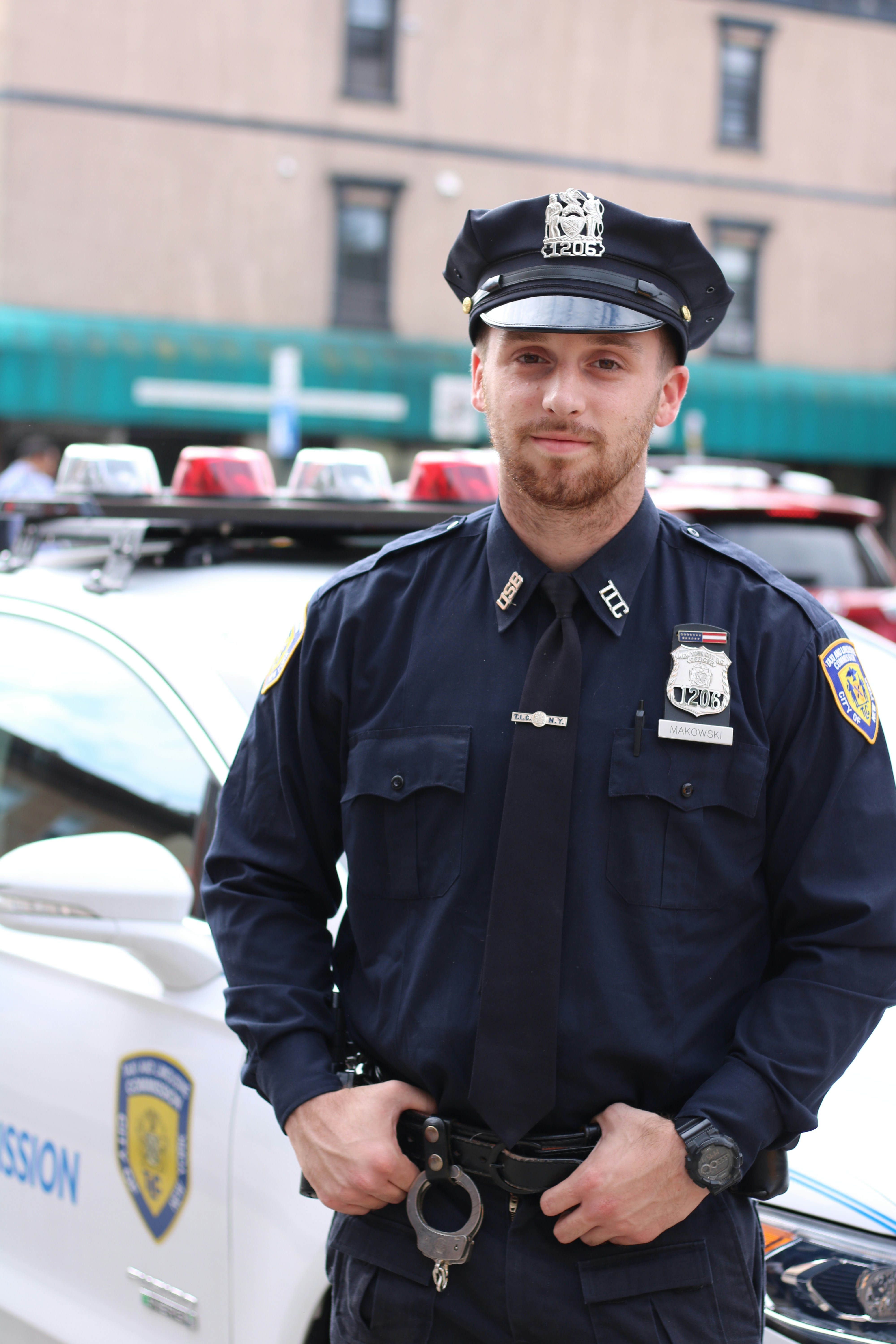 Policjant stoi obok swojego samochodu | Źródło: Unsplash