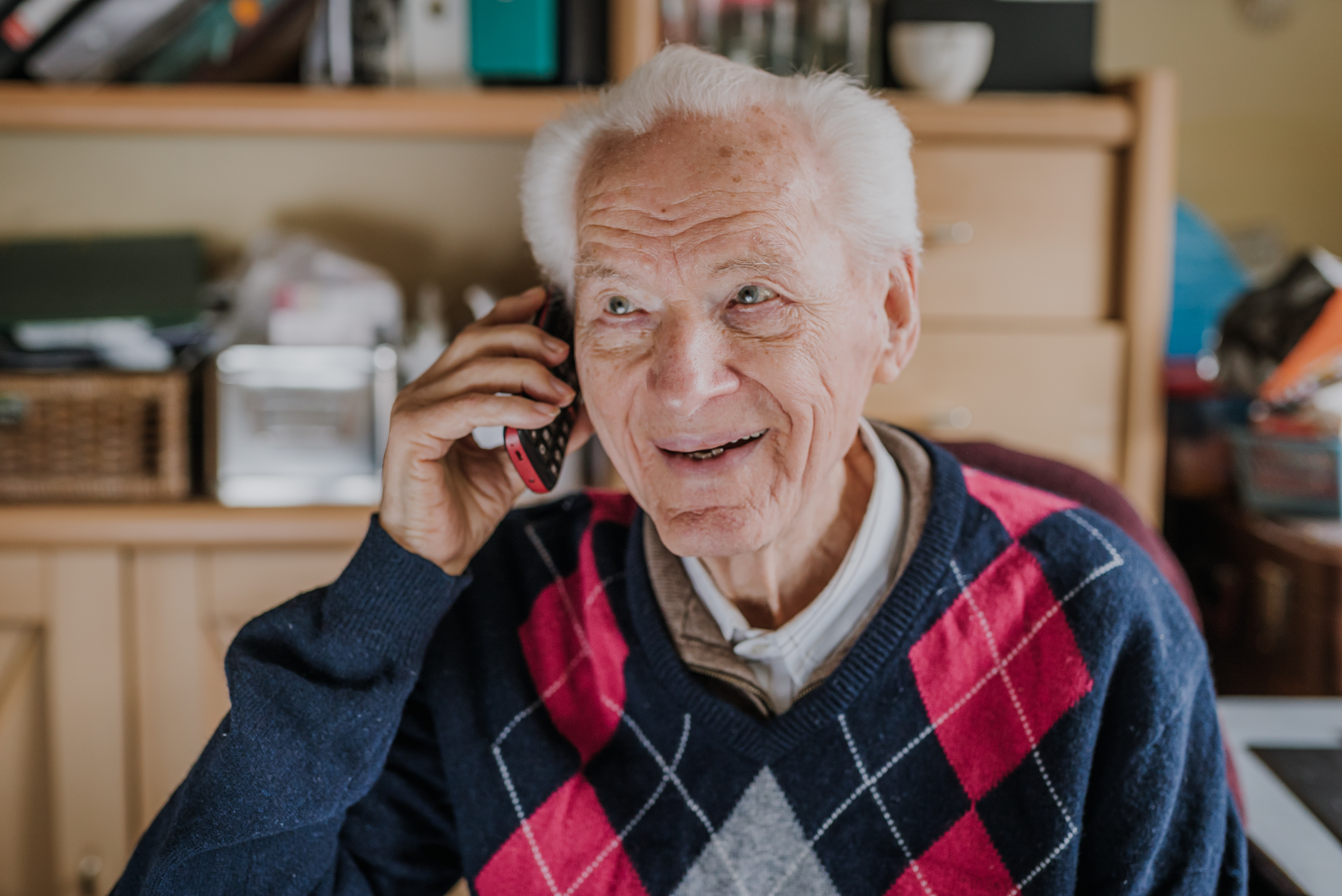 Facet uśmiechający się podczas rozmowy przez telefon | Źródło: Getty Images