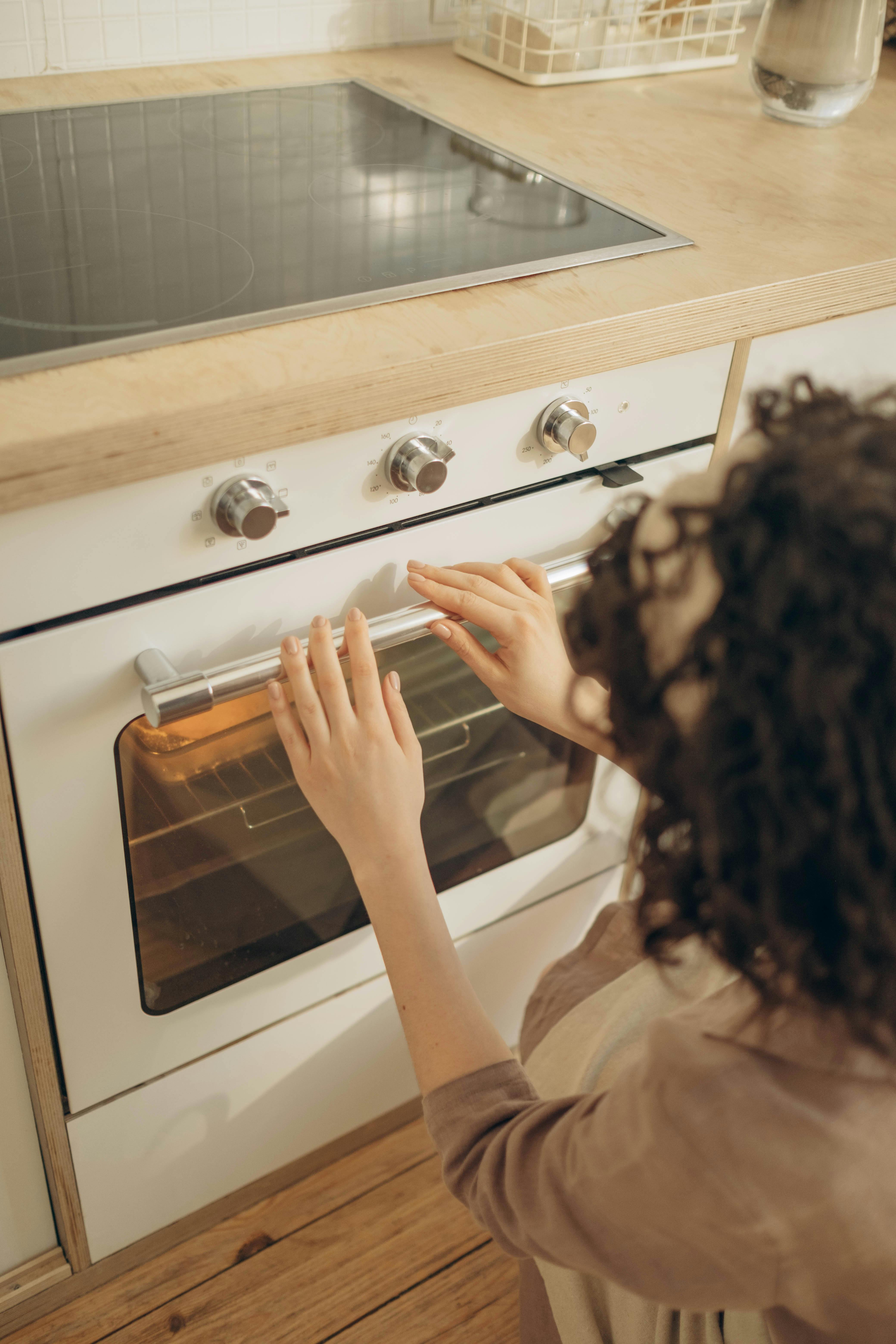 Kobieta sprawdzająca piekarnik | Źródło: Pexels