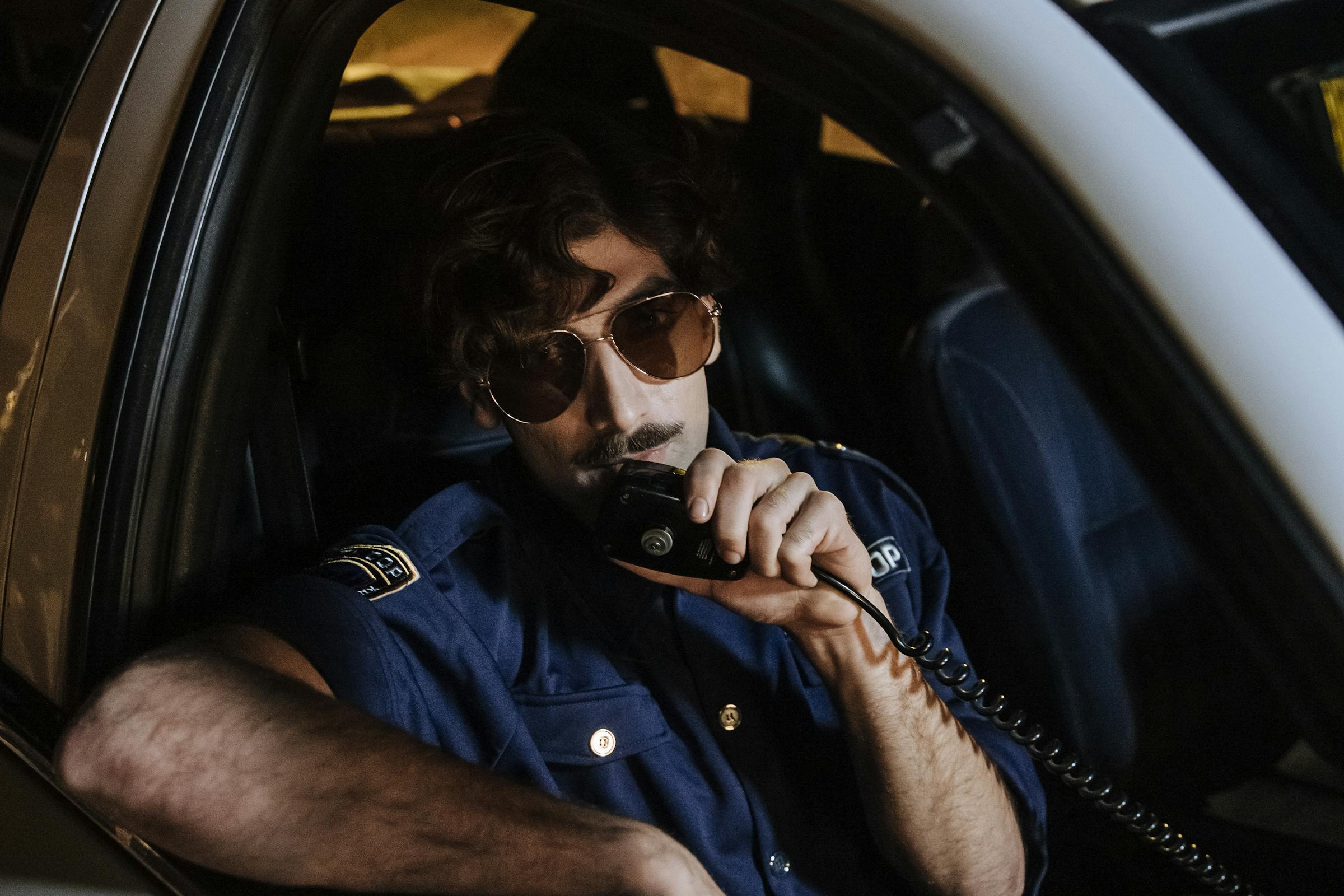 Policjant korzystający z domofonu w radiowozie | Źródło: Pexels