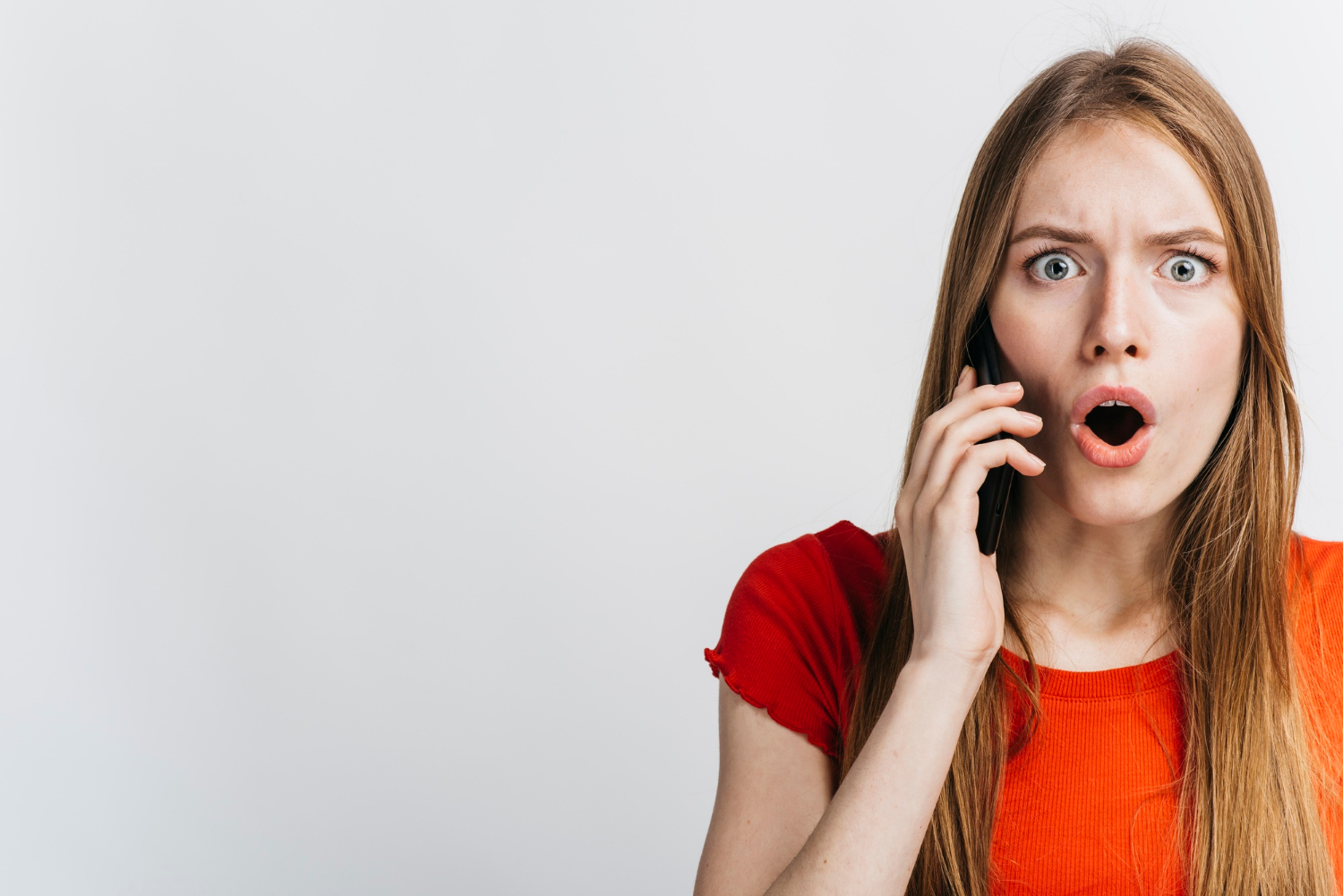 Zaskoczona kobieta rozmawiająca przez telefon | Źródło: Freepik