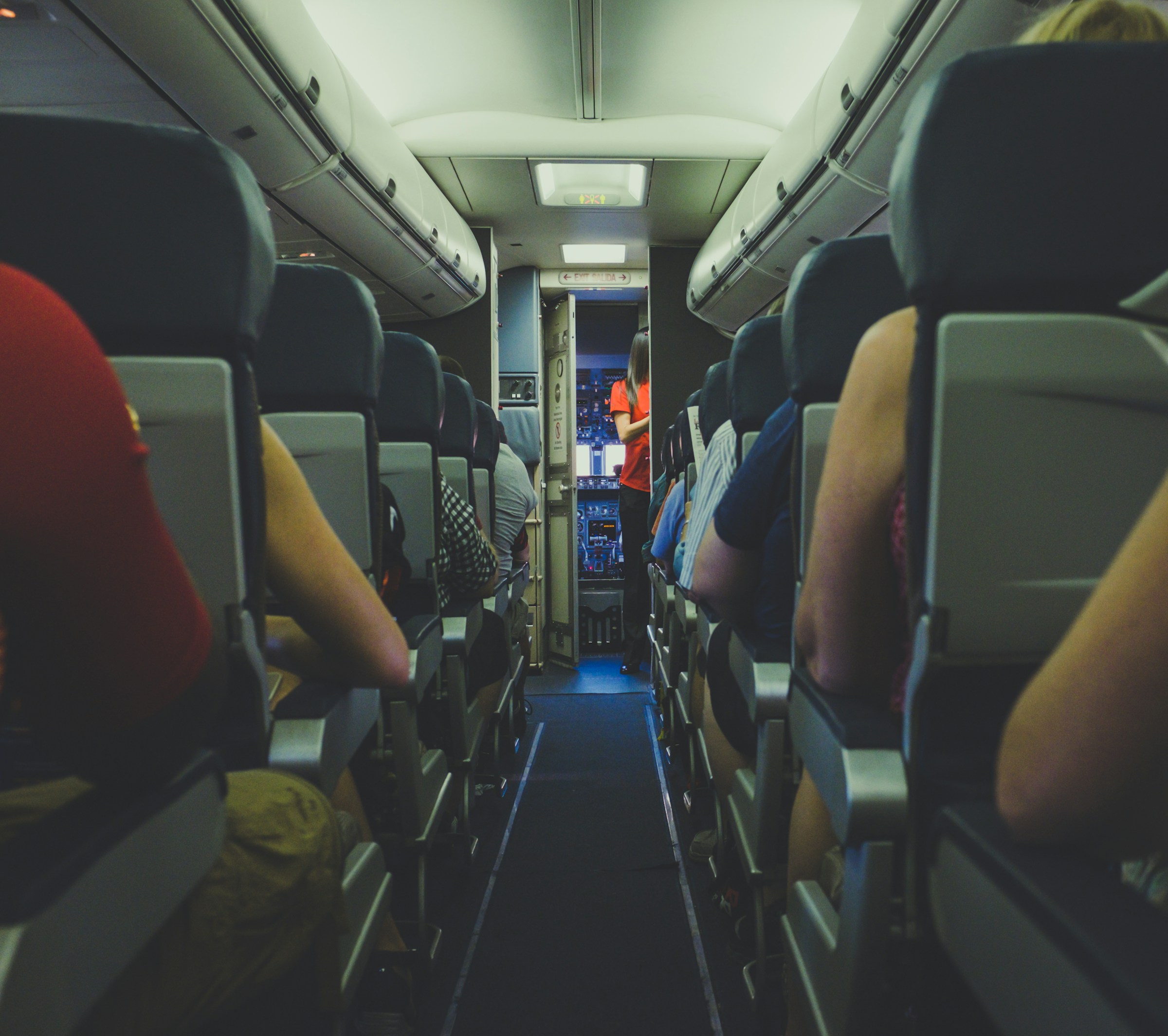 Stewardesa i pasażerowie w przedniej części samolotu | Źródło: Unsplash