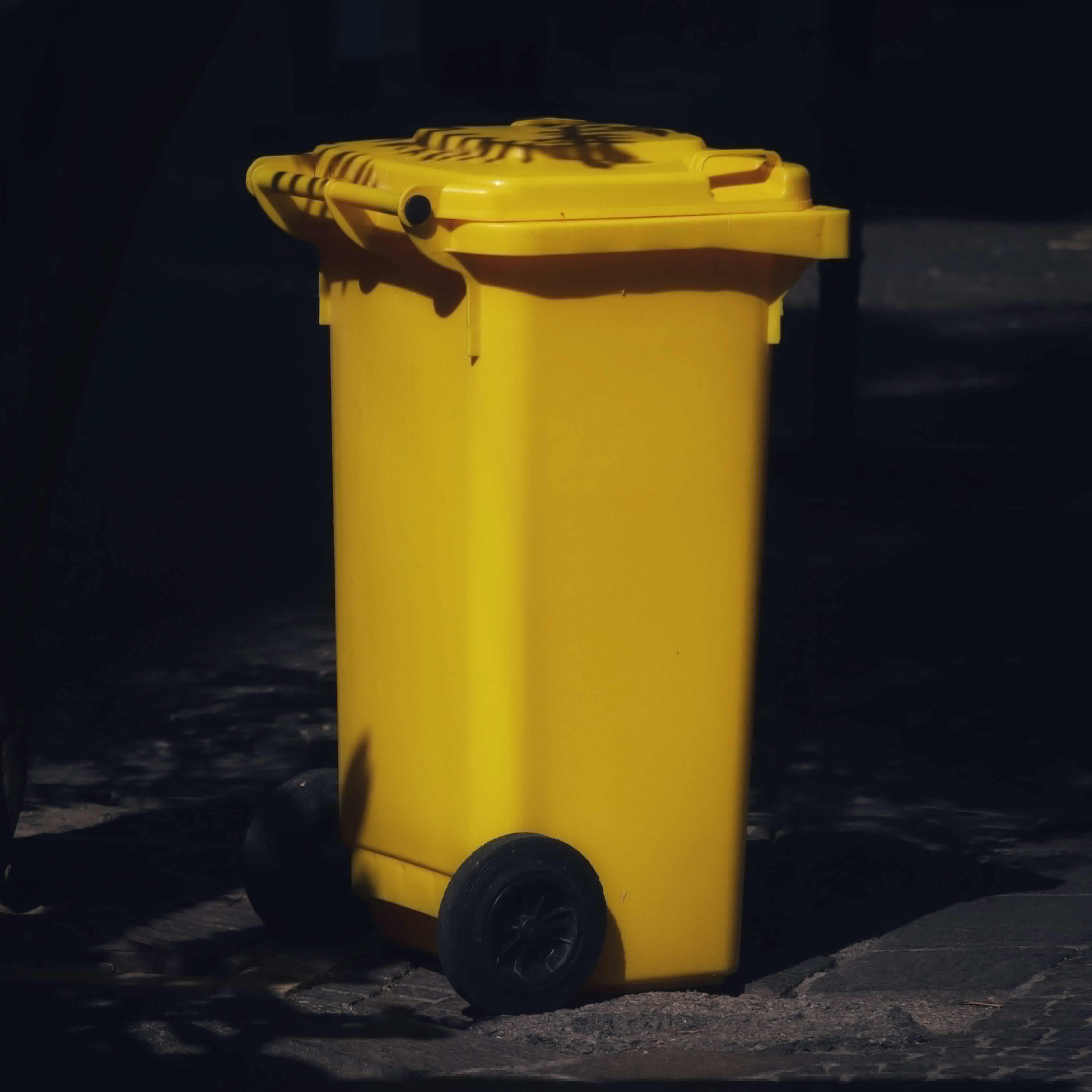 Kolorowy kosz na śmieci na podwórku | Źródło: Pexels
