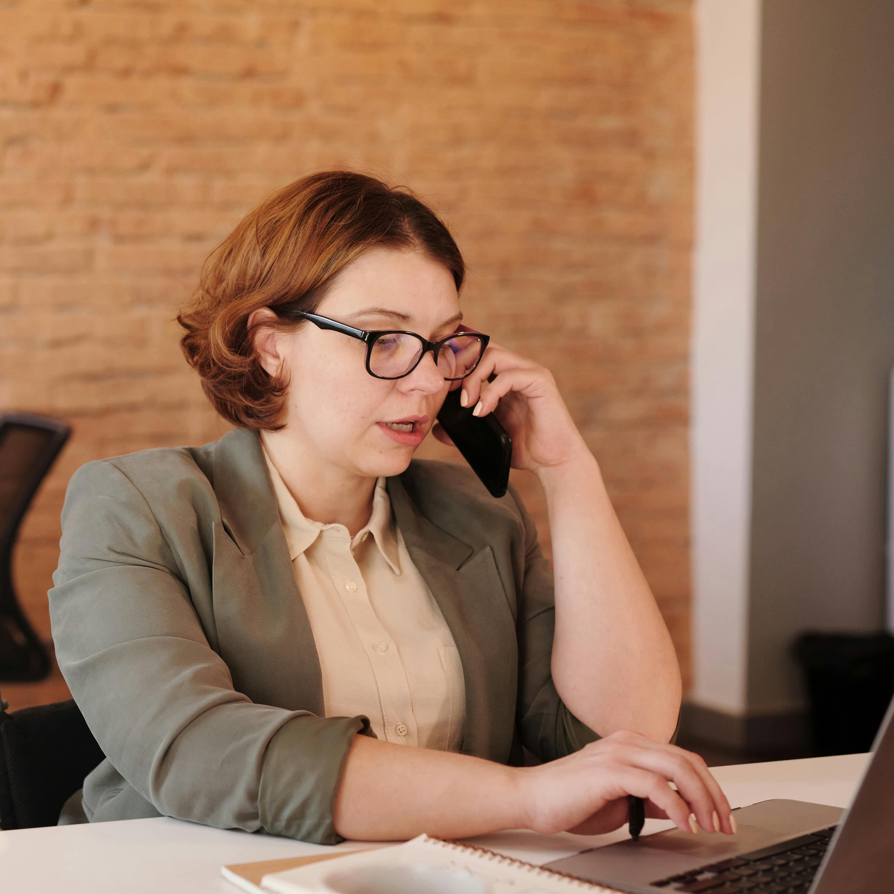 Kobieta rozmawiająca przez telefon w miejscu pracy | Źródło: Pexels