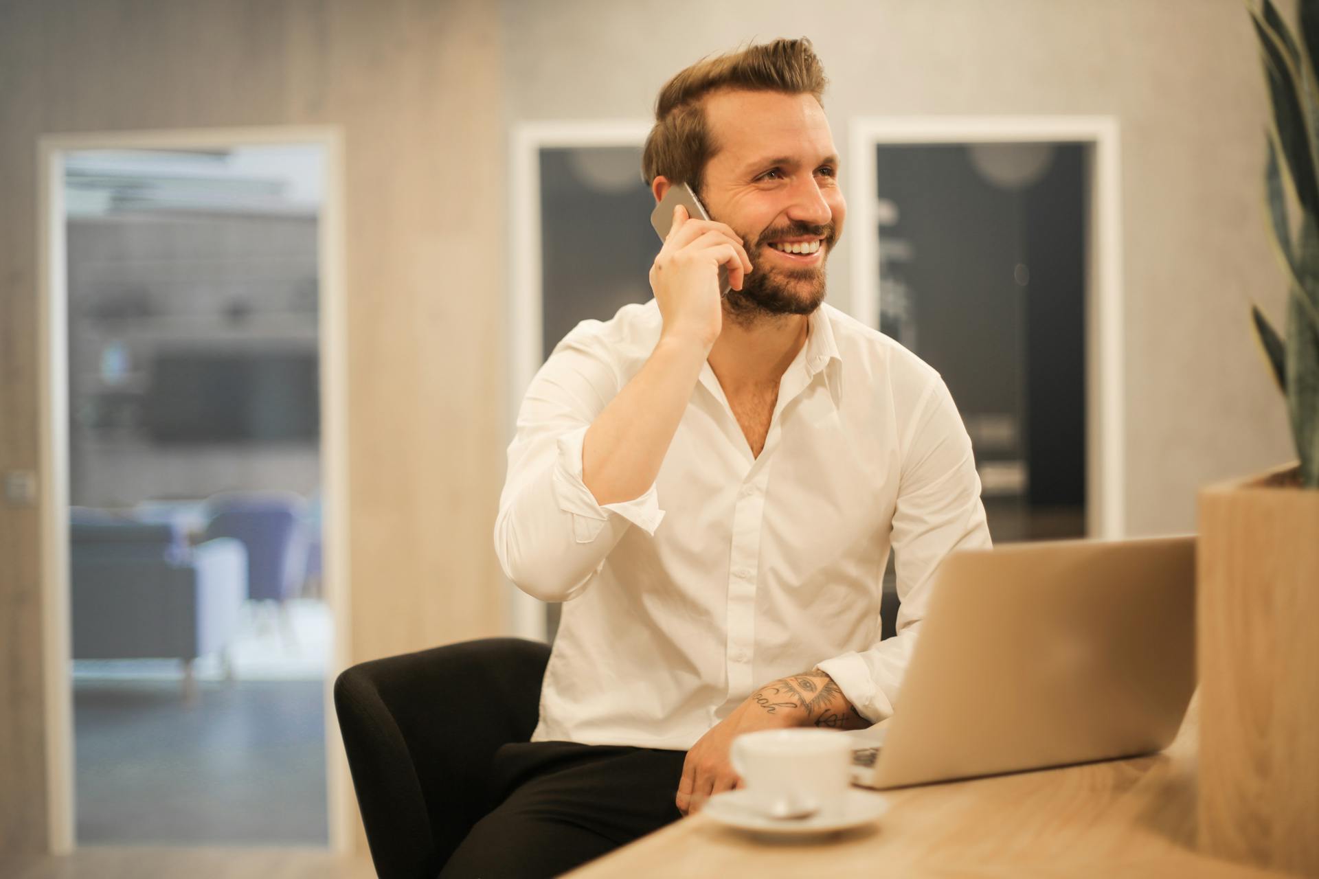 Facet uśmiechający się do telefonu | Źródło: Pexels