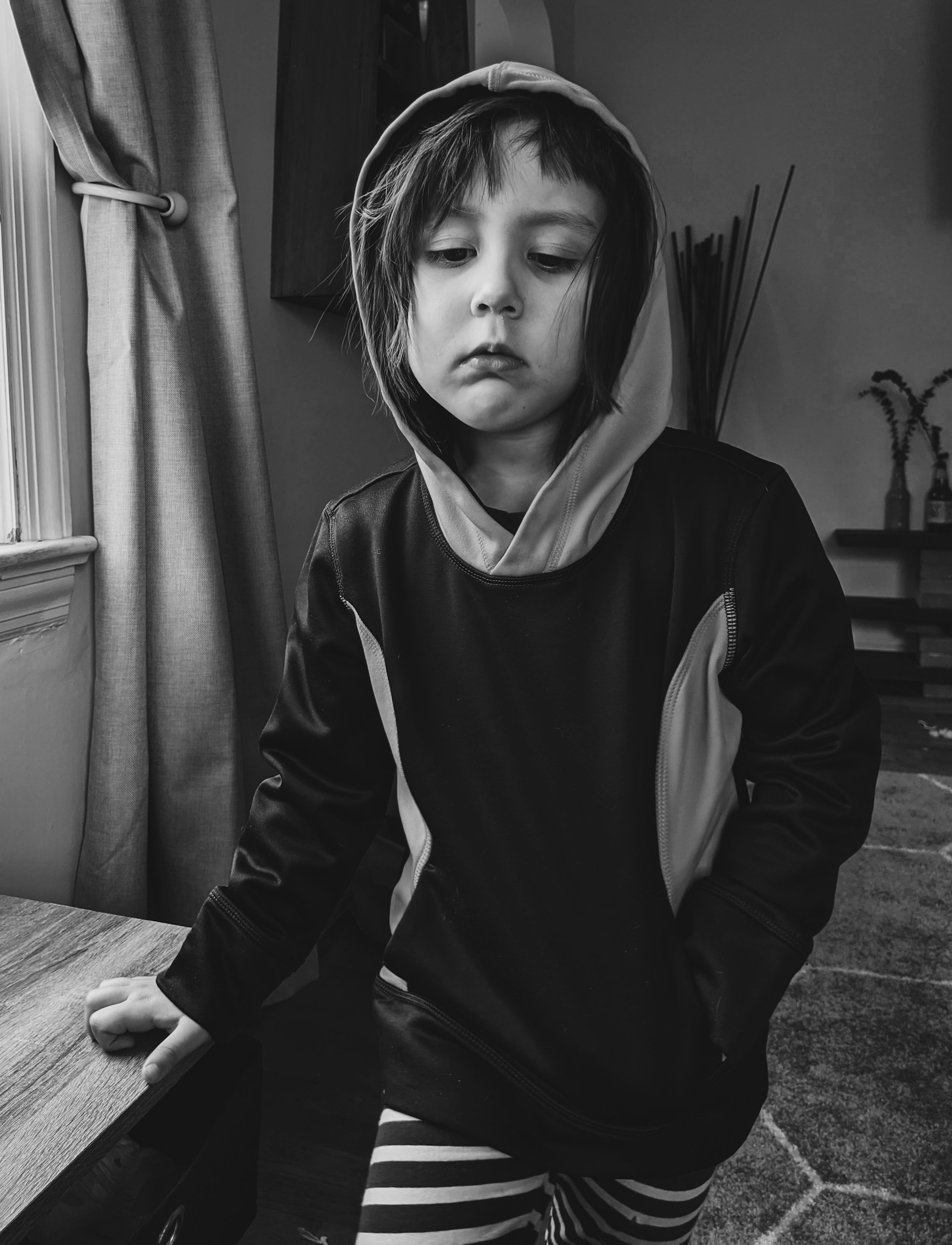 Ujęcie zamyślonego dziecka w skali szarości | Źródło: Unsplash