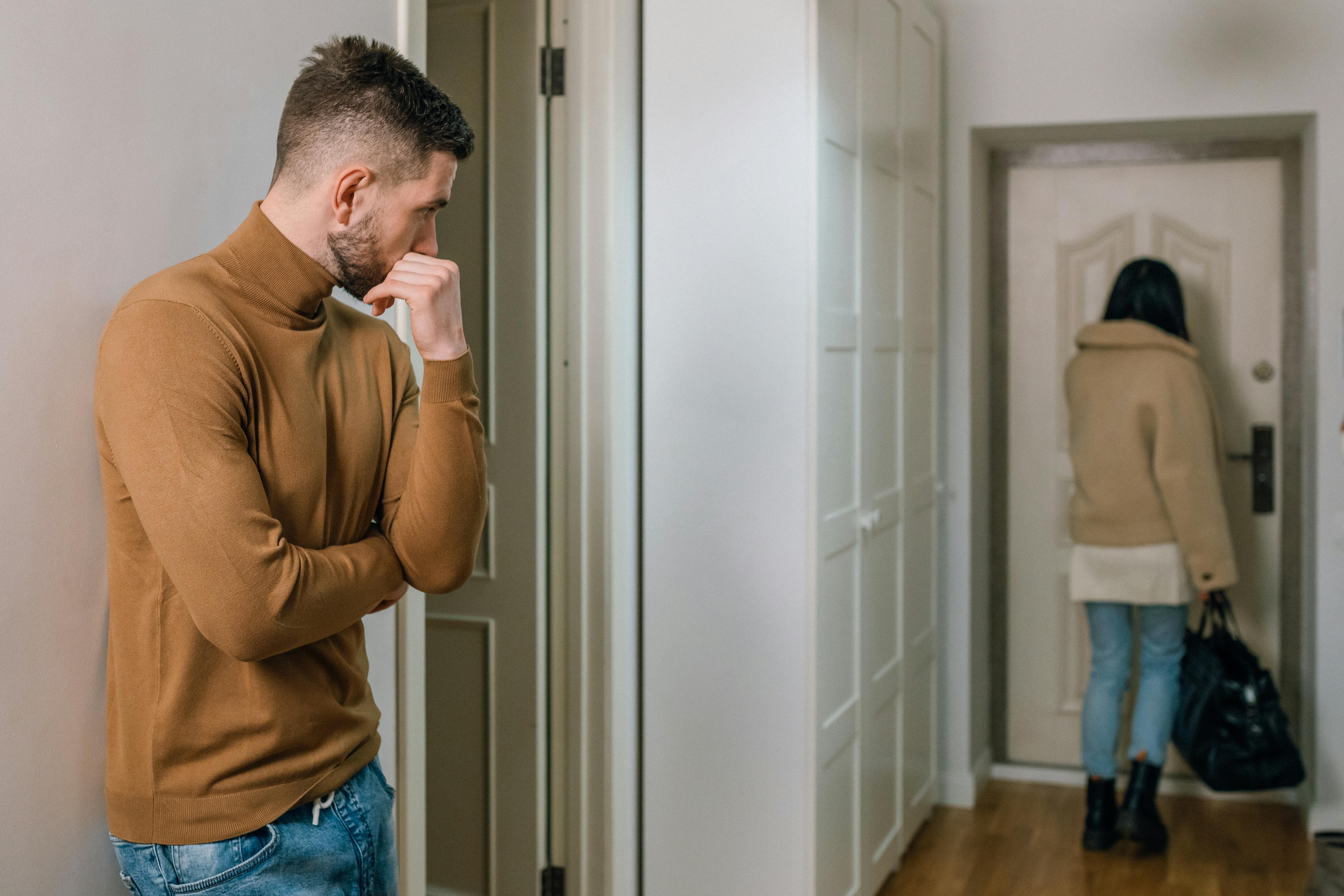 Facet patrzy, jak jego partnerka wychodzi z mieszkania z torbą | Źródło: Pexels
