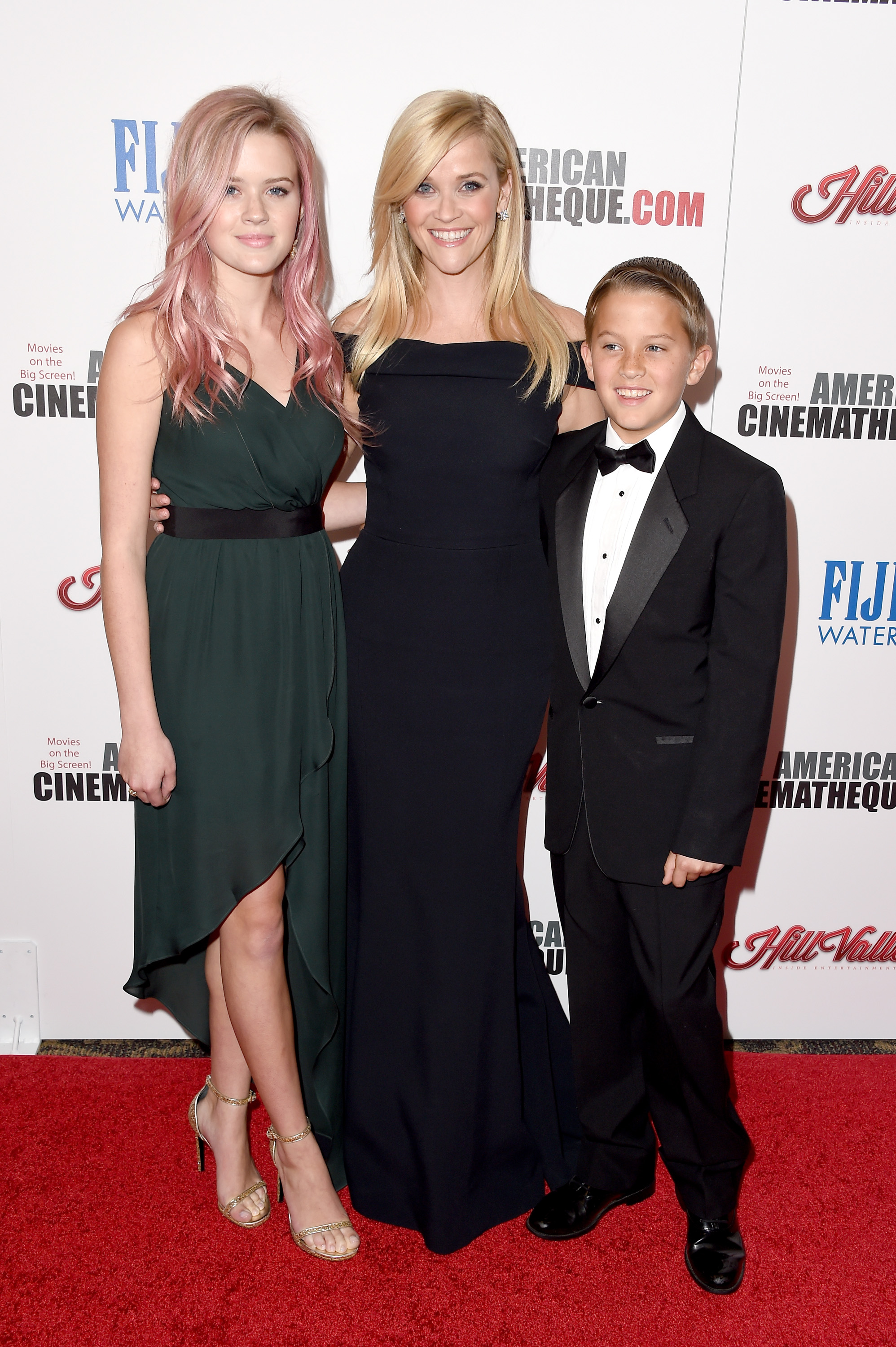 Reese Witherspoon pozuje z Avą Phillippe i Deaconem Phillippe’em podczas ceremonii wręczenia nagrody American Cinematheque, która została jej przyznana, stojąc między swoimi dziećmi w eleganckiej czarnej sukni. | Źródło: Getty Images
