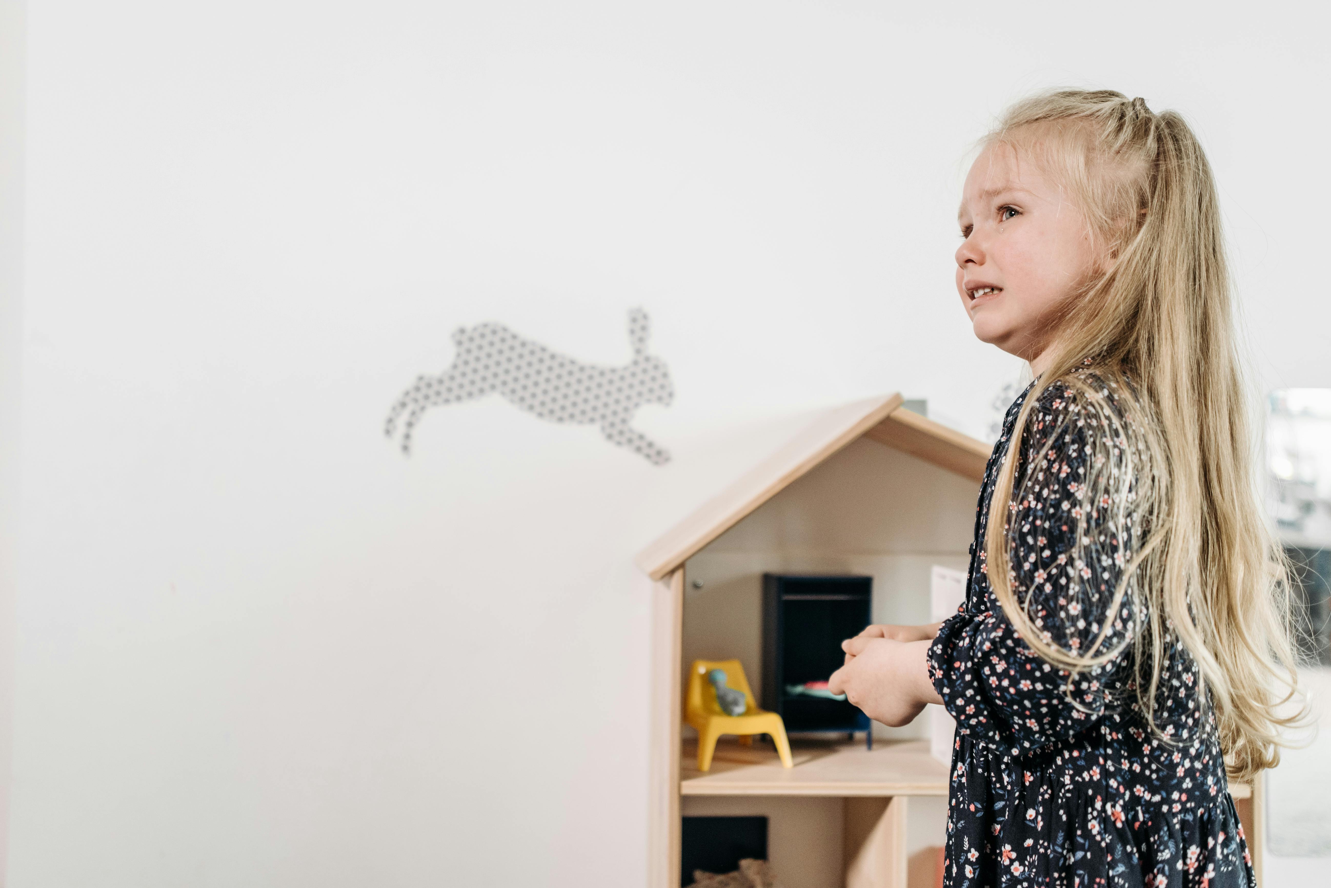 Płacząca dziewczynka i domek dla lalek | Źródło: Pexels