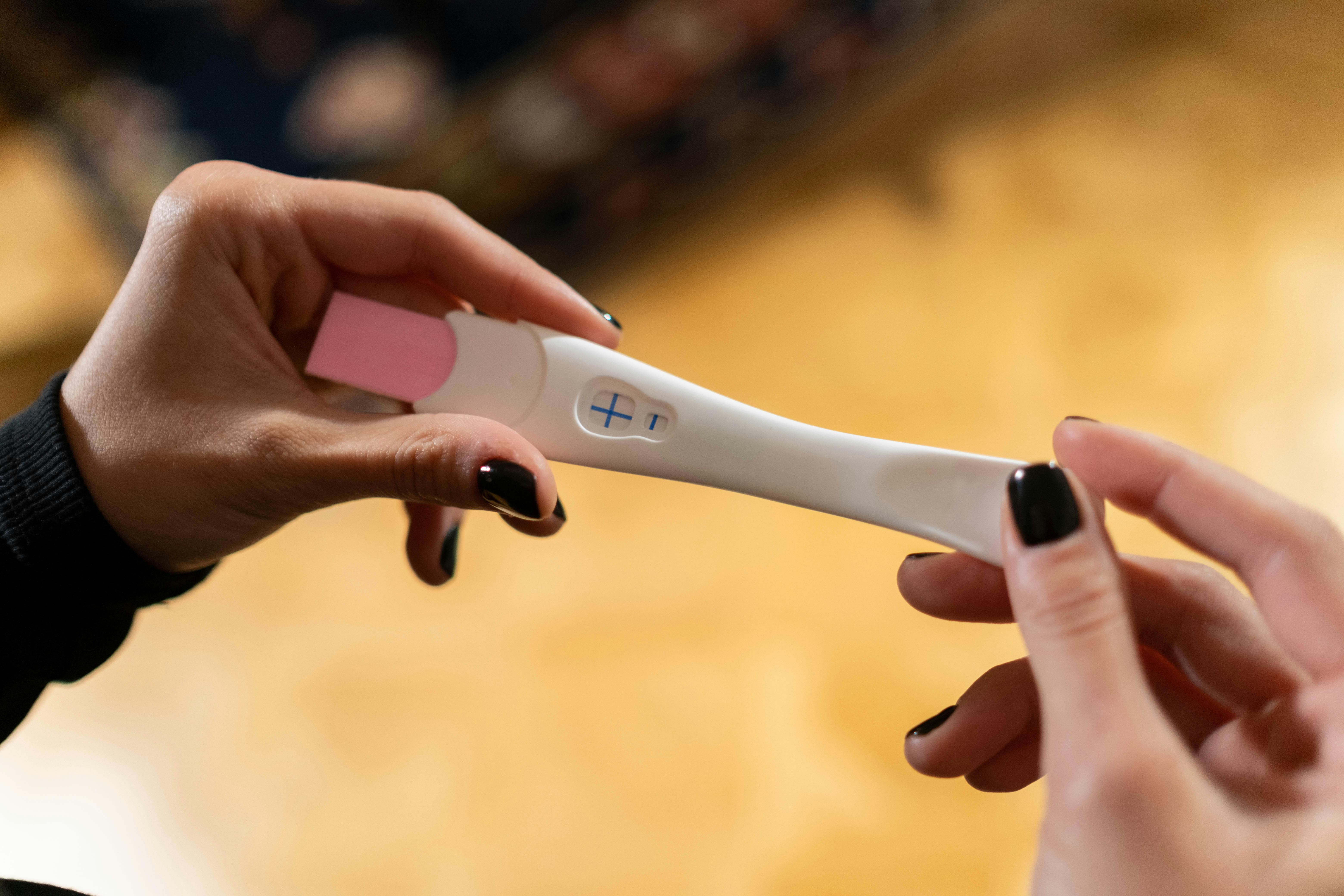 Kobieta trzymająca pozytywny test ciążowy | Źródło: Pexels