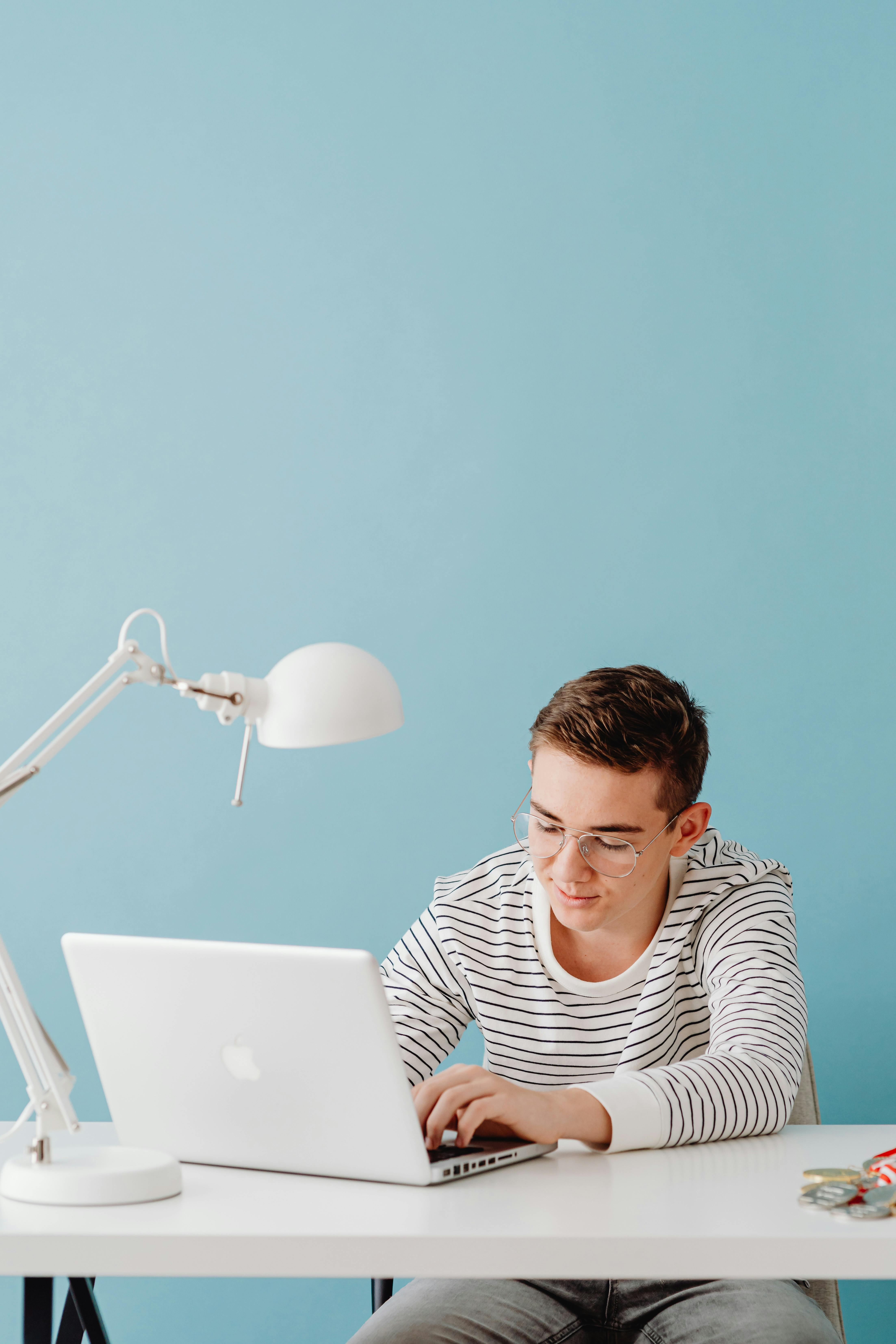 Facet pracujący na laptopie w swoim domowym biurze | Źródło: Pexels