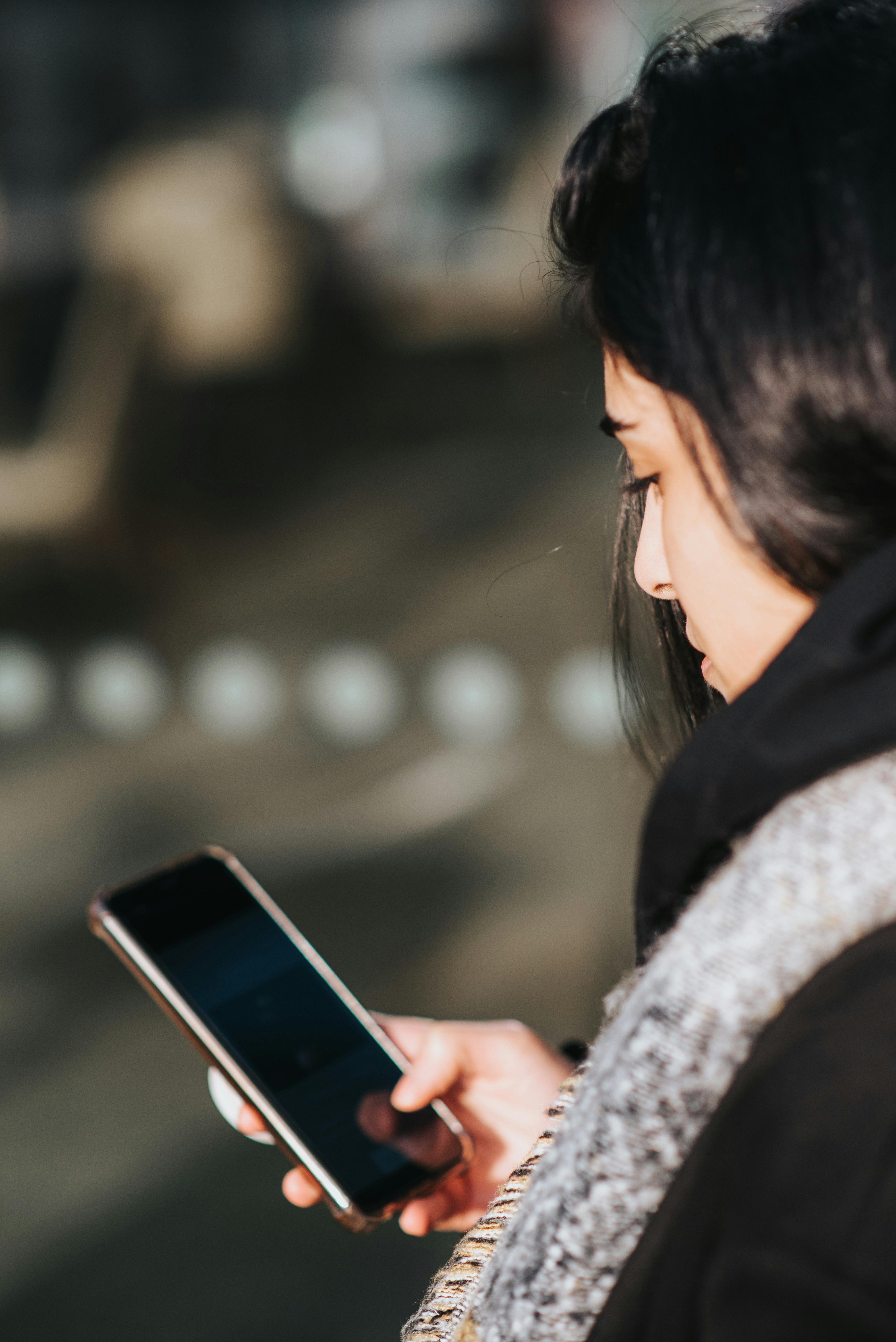 Kobieta uważnie obserwująca swój telefon | Źródło: Pexels