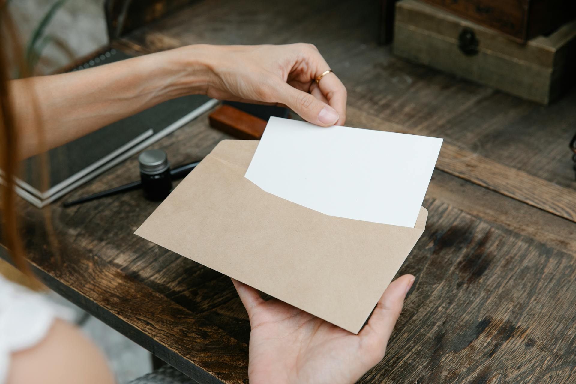 Kobieta wkładająca list do koperty | Źródło: Pexels